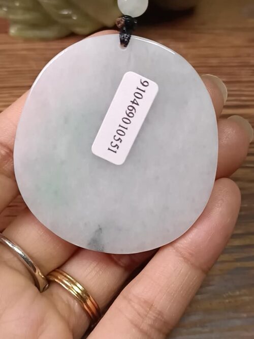a hand holding a white stone with a white label
