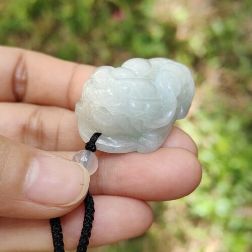 एक हाथ में जेड का हार पकड़े हुए
