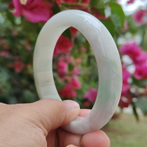 a hand holding a white bracelet