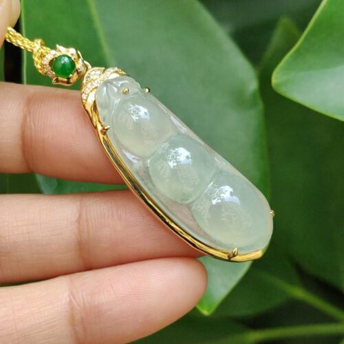 a hand holding a jade necklace