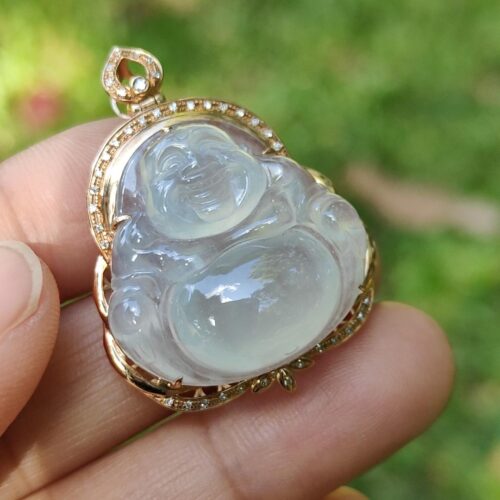 a hand holding a jade pendant