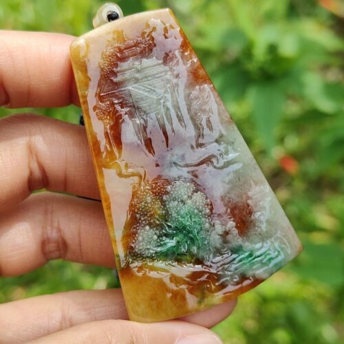 Una mano sosteniendo un colgante de piedra.