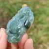 a hand holding a jade object
