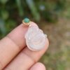 a hand holding a jade pendant