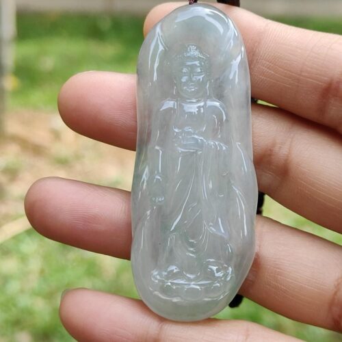 a hand holding a jade pendant