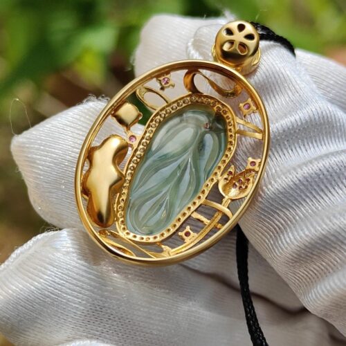 a gold pendant with a blue stone in it