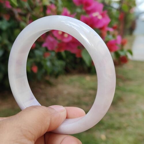 一只手拿着一个白色手镯