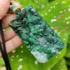 Una mano sosteniendo un colgante de jade.