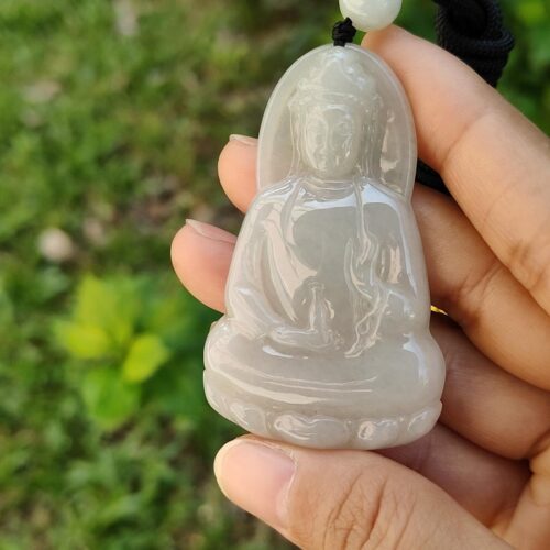 Una mano sosteniendo un colgante de jade.