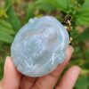 Una mano sosteniendo un colgante de jade.