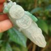 Una mano sosteniendo un colgante de jade.