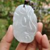 Una mano sosteniendo un colgante de jade.