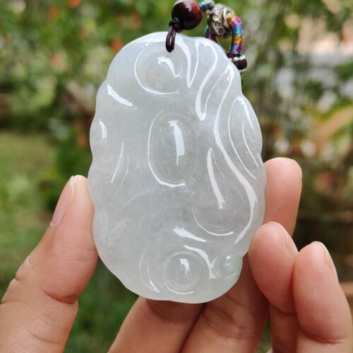 Una mano sosteniendo un colgante de jade.
