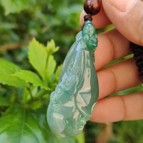 Una mano sosteniendo un colgante de jade.