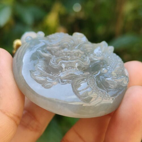 Una mano sosteniendo un colgante de jade.