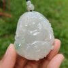 a hand holding a jade pendant