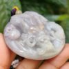 Una mano sosteniendo un colgante de jade.
