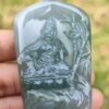 a person holding a jade pendant