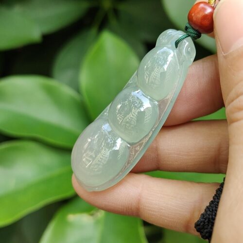 a hand holding a jade necklace