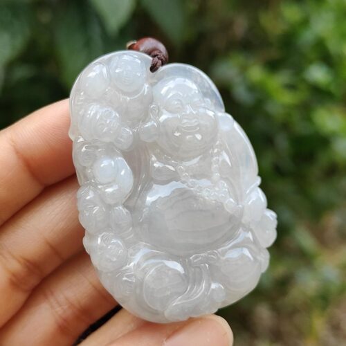 a hand holding a jade pendant