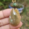 Una mano sosteniendo un colgante de jade.