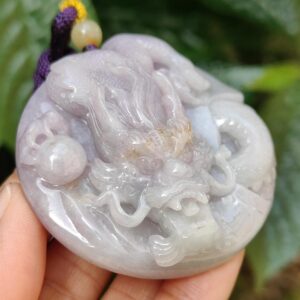 Una mano sosteniendo un colgante de jade.