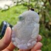 Una mano sosteniendo un colgante de jade.