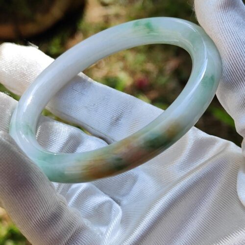 a hand in glove holding a white ring