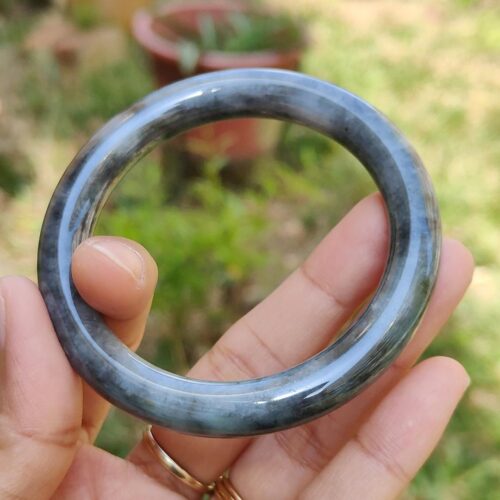 a hand holding a round stone ring