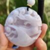 Una mano sosteniendo un colgante de jade.