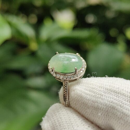 a hand wearing a glove holding a ring