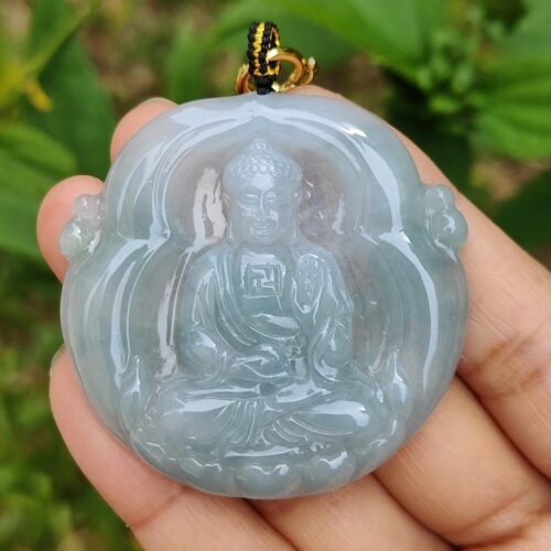 Una mano sosteniendo un colgante de jade.