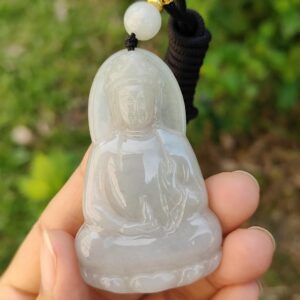 Una mano sosteniendo un colgante de jade.