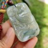 Una mano sosteniendo un colgante de jade.