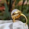a gold ring with a pearl in it