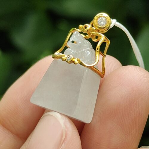 a hand holding a small white stone object