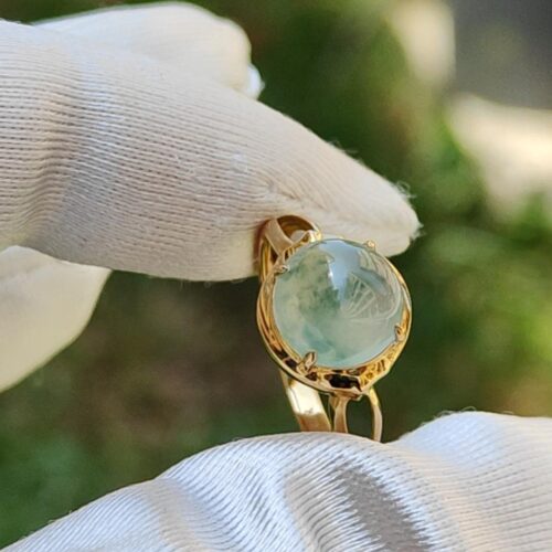 a hand wearing a glove holding a ring