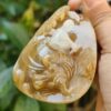 a hand holding a stone pendant