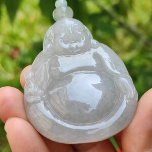 Una mano sosteniendo un pequeño buda blanco.