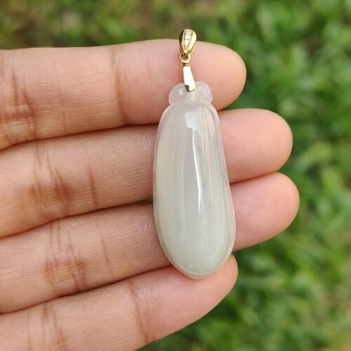 a hand holding a white pendant