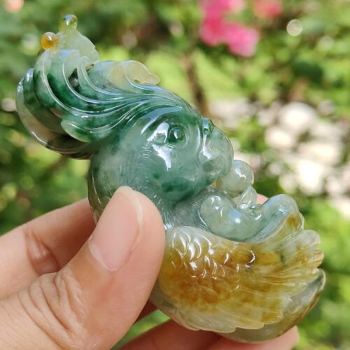 a hand holding a jade bird