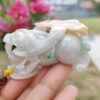 a hand holding a small white stone animal