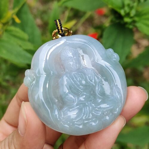 Una mano sosteniendo un colgante de jade.