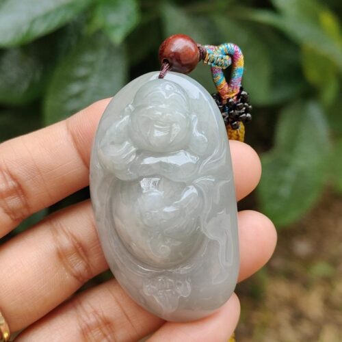 a hand holding a jade pendant