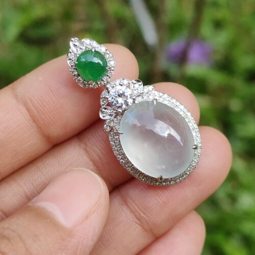 une main tenant une paire de boucles d'oreilles