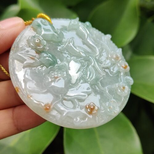 a hand holding a round object with a gold cord