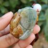 Una mano sosteniendo un colgante de jade.