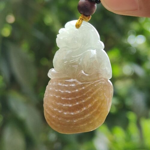 une main tenant un pendentif en jade