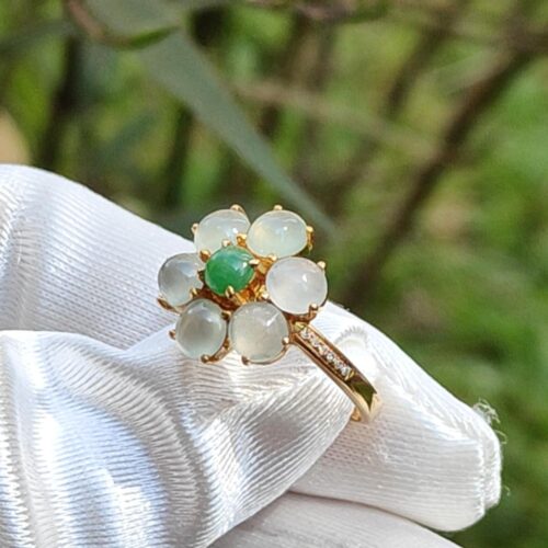 a hand wearing a white glove with a ring with stones