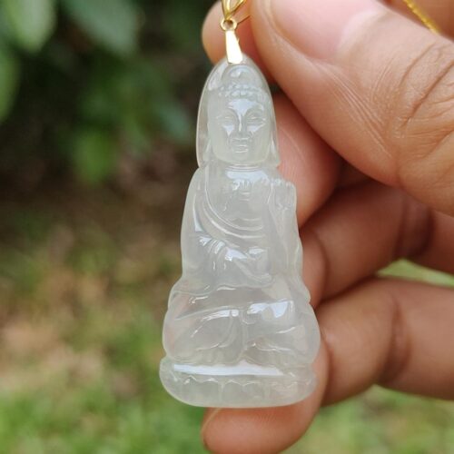 a hand holding a jade pendant